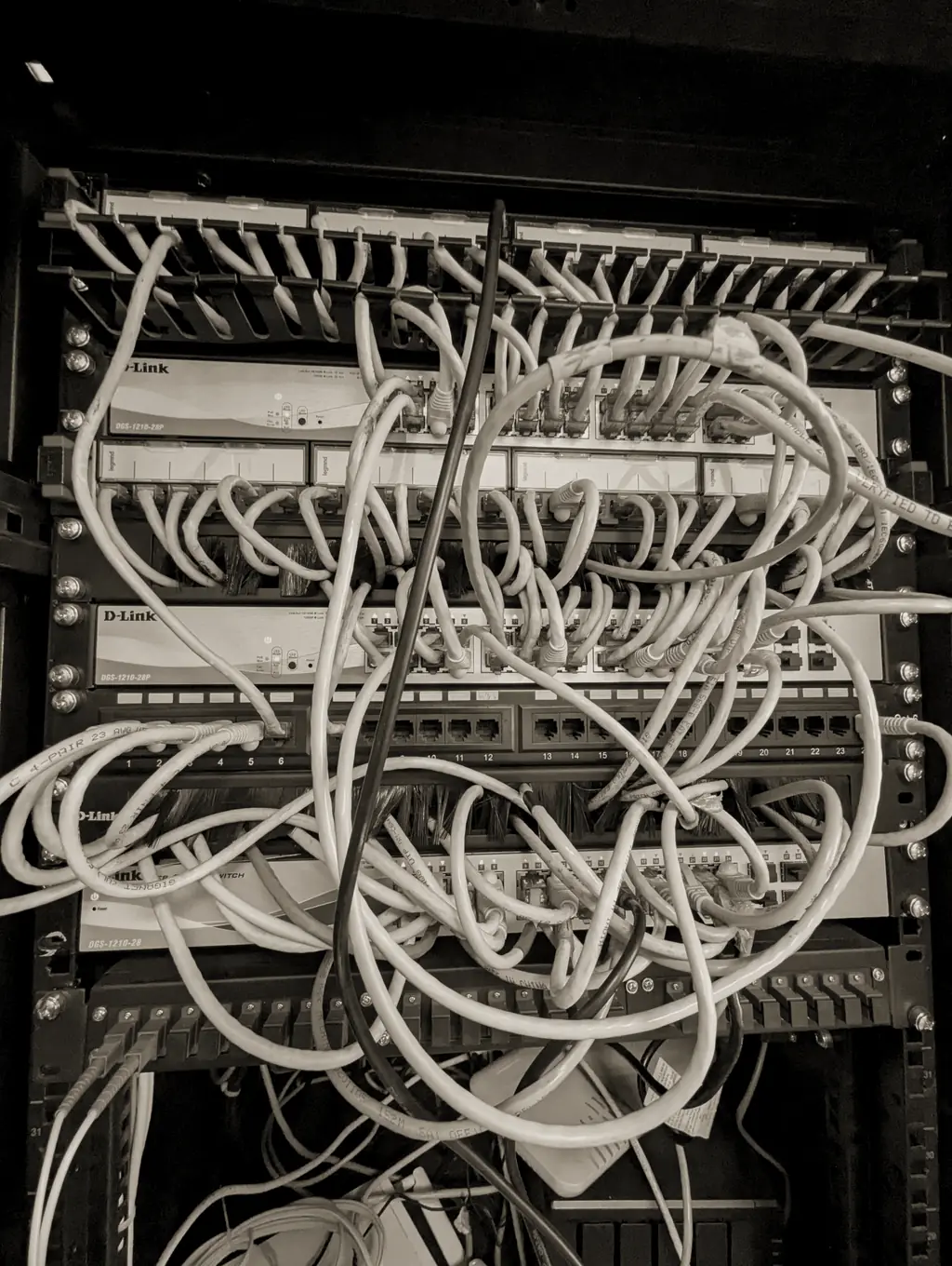 A rack of patch panels with tangled network cables