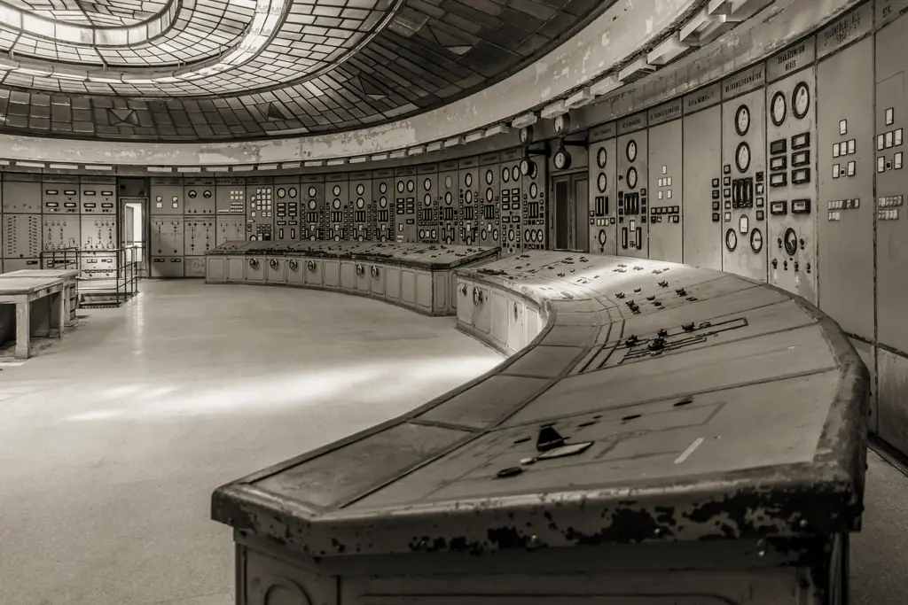 A disused control room with banks of analogue gauges and switches